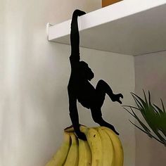 a monkey is standing on top of bananas and reaching up to reach the banana peel