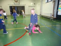 several children are playing in an indoor basketball court