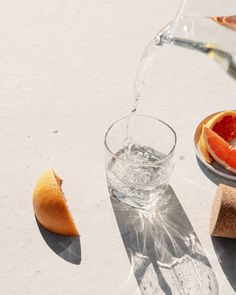 an orange slice is being poured into a glass