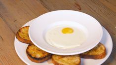 an egg is in the middle of toast on a white plate