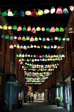 many colorful lights hanging from the ceiling in a building