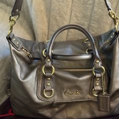 Coach J1149-F15447 Ashley Bronze Leather Satchel/Shoulder Purse 14x10x6 Double Handle With Detachable Shoulder Strap Dust Bag Included Pristine Condition. No Marks Bronze Exterior Black Interior Authenticated. Follow R Code Pictured Coach Satchel Shoulder Bag With Gunmetal Hardware, Coach Satchel With Gunmetal Hardware, Coach Shoulder Satchel With Silver-tone Hardware, Black Coach Satchel With Silver-tone Hardware, Brown/black Coach Bag, Shoulder Purse, Black Interior, Leather Satchel, Coach Bags