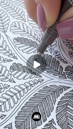 someone using a pen to draw an intricate pattern on paper with markers and inking