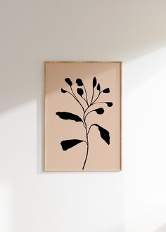 a black and white plant on a beige background in a wooden frame hanging on the wall