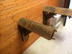 two wooden benches sitting next to each other near a toilet in a room with wood paneling