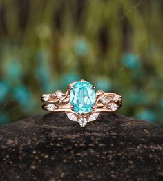 a ring with an oval blue topazte surrounded by white diamonds on a rock