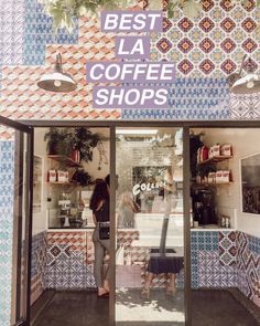 two women standing in front of a coffee shop with colorful tiles on the wall and windows