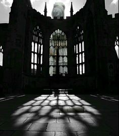 the shadow of a person's head is cast on an old building with large windows