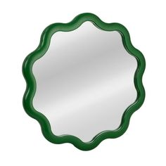 a round mirror with green trim around it on a white wall or floor, in the shape of a scalloped circle