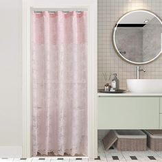 a bathroom with a pink shower curtain next to a white sink and mirror on the wall