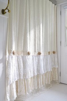 a curtain with ruffles hanging from it's side in front of a door