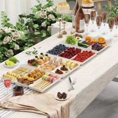 a table filled with different types of food and glasses of champagne next to each other