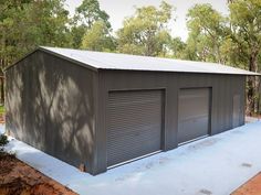 two garages are shown in the middle of a dirt area with trees behind them