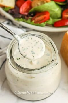 a spoon full of dressing next to a salad