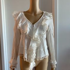 White Long Sleeve Blouse With Embroidered Lace Embellishment On Ends Of Sleeves, Shoulders And Front 100% Silk In Overall Great Condition With Only A Couple Very Small Tears On The Shoulders As Shown In Images Chest - 17" Sleeve - 23.5" Length - 24.5" White V-neck Blouse With Ruffles, Elegant V-neck Lace Top For Brunch, Elegant White V-neck Lace Top, V-neck Blouse With Lace Trim For Daywear, V-neck Blouse With Lace Trim For Brunch, Feminine Embroidered V-neck Blouse, Fitted Feminine Embroidered Top, Embroidered V-neck Top For Daywear, Long Sleeve Top With Floral Embroidery For Weddings