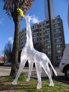 a statue of a giraffe standing next to a tree