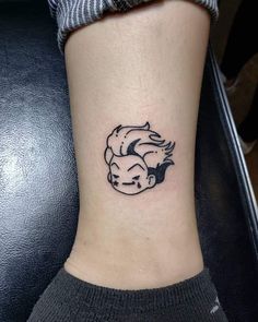 a small tattoo on the ankle of a woman with a horse's head in black ink