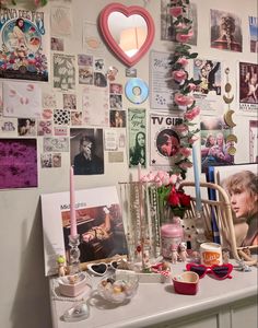 a cluttered desk with pictures and candles on it