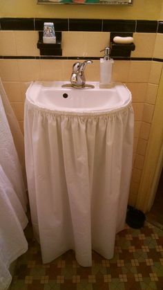 a white sink sitting under a bathroom mirror