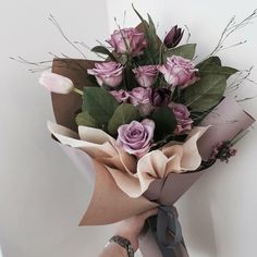 a bouquet of flowers is wrapped in brown paper