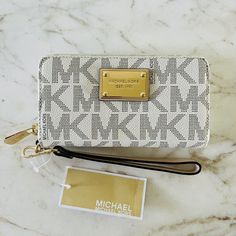 100% Leather Metal Accents Ivory Classic Logo Print 7.25" Width, 4.25" Height, 1" Depth Dust Bag Not Included. Michael Kors Beige Rectangular Wallet, Michael Kors Elegant Clutch Wallet, Elegant Michael Kors Clutch Wallet, White Rectangular Clutch With Zipper Closure, Elegant White Clutch With Zipper Closure, Michael Kors Luxury Beige Wallet, Luxury Beige Michael Kors Wallet, Elegant Michael Kors Clutch For Travel, Designer White Bags With Card Slots