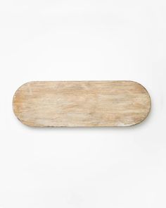 a wooden skateboard laying on top of a white wall