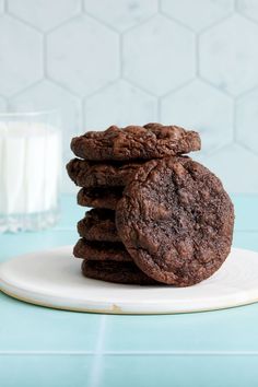 chocolate cookies stacked on top of each other next to a glass of milk