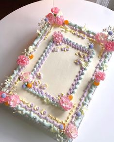 a cake decorated with flowers and beads on a white table cloth covered in icing