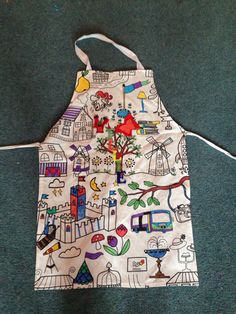 an apron is sitting on the floor next to a bag with pictures and words painted on it