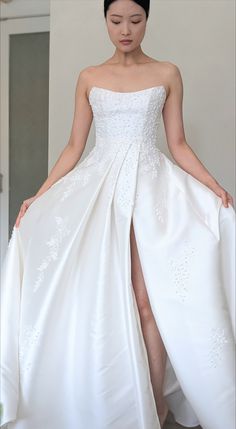 a woman in a white wedding dress with her legs crossed