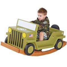 a little boy riding on a green toy jeep