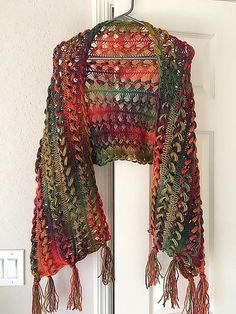 a crocheted shawl hanging on a door