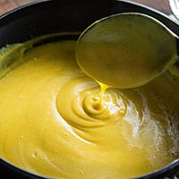 a spoon in a pot filled with yellow liquid