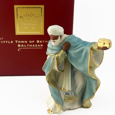 a figurine of a man holding a candle in front of a red box