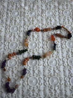 Vintage multicolored gemstone beaded necklace, featuring amethyst, carnelian, crystal quarts, onyx, agate. The necklace consists of one strand of stone chip beads, arranged by color with brass spacers between the different type of gemstones. Closes with screw barrel clasp at the back Era - 1980s Approx. Length (with clasp) - 24 inches / 61 cm Condition - Very good vintage condition, some dents on the stones! Bohemian Amethyst Beaded Necklaces For Jewelry Making, Spiritual Amber Beaded Necklaces With Natural Stones, Spiritual Amber Crystal Necklaces With Gemstones, Spiritual Amber Beaded Necklace With Natural Stones, Amber Crystal Necklace For Meditation With Natural Stones, Spiritual Amber Gemstone Necklace, Spiritual Amber Crystal Necklace With Stones, Adjustable Round Bead Mineral Crystal Necklaces, Multicolor Agate Necklace For Gift