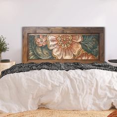 a bed with white sheets and a painting on the wall