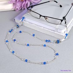 Fun and sporty for you weekend wear, our clear eyeglass chain feature blue beads for a hint of color. You will never have to worry about misplacing your eyeglasses again. Makes for a great gift for yourself or a loved one. Rubber loops adjust to fit most glasses frames.   🦉Product Details:  * Approx. Length - 31 1/2 in (including rubber loops) * Chain Weight: 1.5 oz * Bead Color(s): Blue, White * Metal Color: Silver-tone * Material: Glass Beads * Closure: Lobster Claw Clasps and Rubber Loop Ends * Product ID: G241 🎁 Gift packaging available at Checkout ($4.00 USD) - See last image   🦉NOTES: * Not recommended for young children! * The lobster clasps make replacement of the rubber loops easy if they break. * All measurements and weights are approximate and may vary slightly from the liste Blue Beaded Chain Glasses Chains With Round Beads, Blue Beaded Glasses Chains, Blue Glasses Chains With Round Beaded Chain, Blue Beaded Glass Glasses Chains, Trendy Blue Glass Necklace, Handmade Blue Glass Glasses Chains, Elegant Adjustable Blue Glasses Chains, Trendy Blue Glass Glasses Chains, Elegant Blue Adjustable Glasses Chains