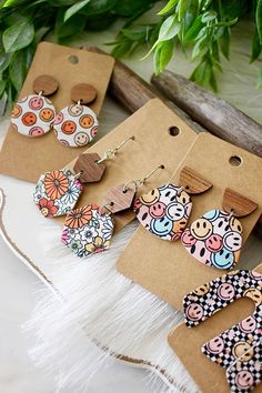 the earrings are made from wood and decorated with colorful flowers, leaves, and polka dots