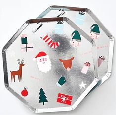 two silver plates with christmas decorations on them and santa clause designs in the middle one