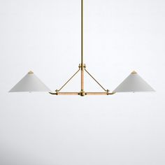 three white lamps hanging from a brass chandelier