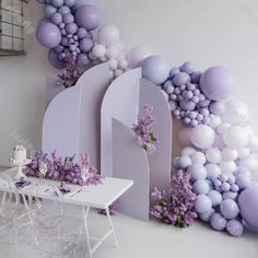 a dining room with balloons and flowers on the wall, along with a white table