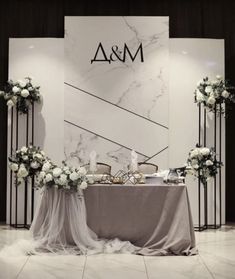 the table is set up with white flowers and greenery for an elegant wedding reception