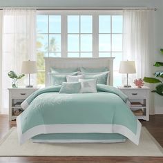 a bed with blue and white comforters in a room