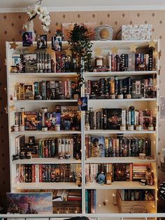 a bookshelf filled with lots of books next to a wall covered in pictures