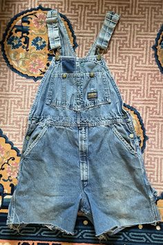 Very cute worn in Osh Kosh adult sized overalls. They have been made into cut offs. Original tag is worn and faded so I can't read what size it is.  All snaps, straps, buttons and zippers work as they should and are al there. Faded in spots. Worn in as you can see and super cute.  Measurements: Waist: front measurement across is about 17" across Bib front from top to bottom about 10" to waist band Rise: almost 13" long Button snap side waist to bottom of short measurement on the side: about 17" Vintage Medium Wash Washed Overalls, Vintage Light Wash Overalls With Pockets, Vintage Cotton Medium Wash Shortalls, Vintage Denim Overalls In Medium Wash, Vintage Medium Wash Denim Overalls, Vintage Denim Shortalls In Medium Wash, Vintage Denim Jumpsuit With Pockets For Streetwear, Vintage Style Medium Wash Denim Shortalls, Vintage Medium Wash Denim Shortalls