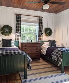 two beds in a room with wooden ceilings and plaid bedding on top of them