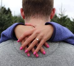 the back of a man's head with pink nails and a ring on his neck