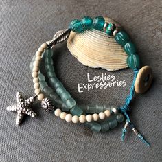 ◾Indonesian glass and Fossil coral bead multi-strand knotted with Irish waxed linen cord ending with a beach stone button clasp. Hill tribe fish bead, Starfish charm and snail bead Length: 7 1/4" I measure bracelets on a mandrel not with a ruler 🩴 The Beachy Jewelry collection ... This collection celebrates the Ocean and Beach. Lots of Sea Life charms and colors. Very natural components like shells, sea glass, hemp, and beach stone. All jewelry comes in a custom gift box ready to give as a gift Turquoise Gemstone Beads Bracelet For Beach, Bohemian Turquoise Starfish Beaded Bracelets, Turquoise Gemstone Beaded Bracelets For Beach, Artisan Green Beaded Bracelets For Beach, Handmade Multi-strand Beach Bracelets, Artisan Hand Wrapped Beaded Bracelets For Beach, Handmade Turquoise Starfish Bracelets, Bohemian Strand Beaded Bracelet With Starfish Charm, Bohemian Beaded Strand Bracelet With Starfish Charm