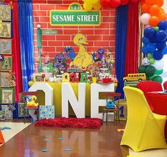 the sesame street birthday party is set up with balloons and streamers on the floor