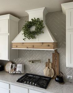 a stove top oven sitting inside of a kitchen next to white cabinets and counter tops